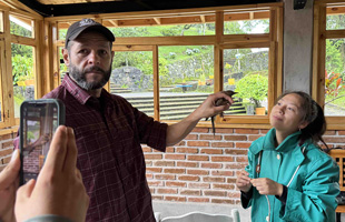 Dr. Ernesto Ruelas-Inzunza holds a clay-colored thrush for CREA student Rosemary Gonzales