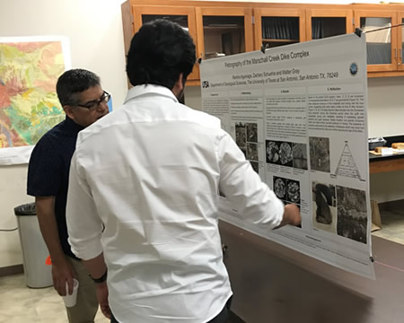 instructors discussing student poster