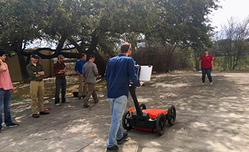 Students outdoors watching a demonstration of ground penetrating radar