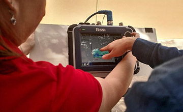 Close up of two people examining the detail of the ground penetrating radar interface