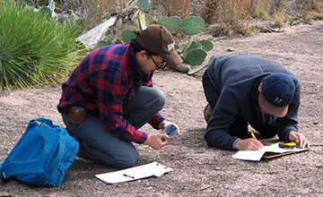 Students taking notes while performing field work