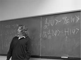 male student writing on chalkboard