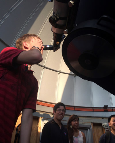 student looking in telescope