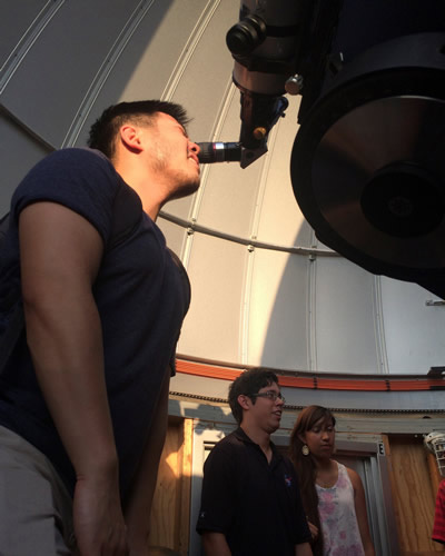 student looking in telescope