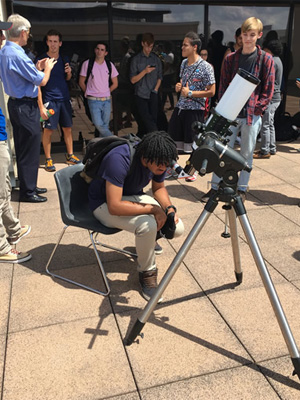 student looking in telescope