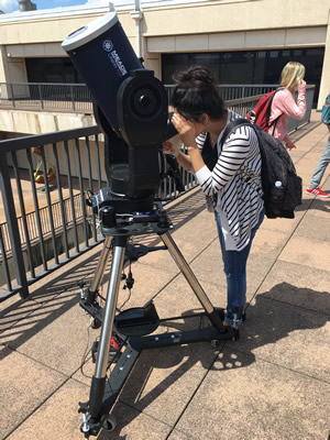 student looking in telescope