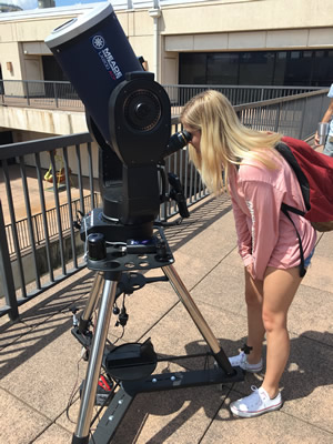 student looking in telescope