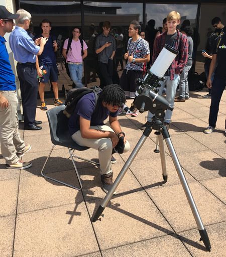 student looking in telescope