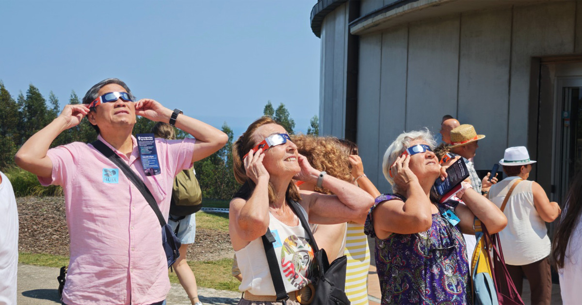 people viewing solar eclipse near the Jurassic Museum in Colunga, Spain