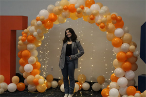 person in front of UTSA balloon arch