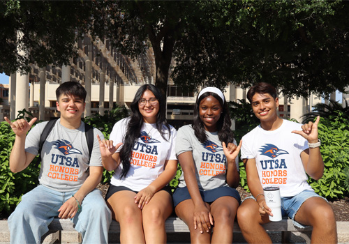 four students on campus bench