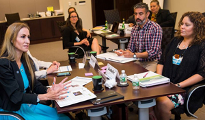 four people at table discussing