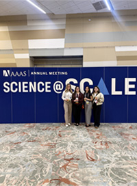 four students in front of AAAS banner