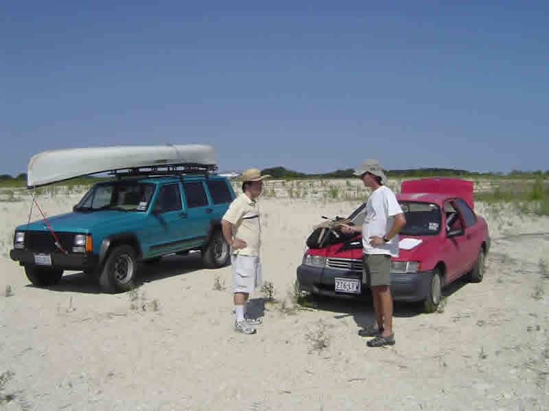 two researchers talking near two cars