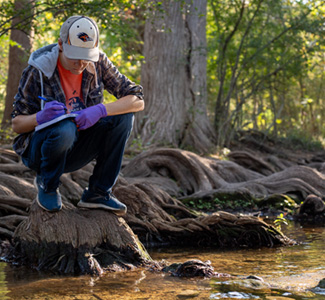 Ronny Saunders taking notes by creek