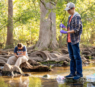 Ronny Saunders with water sample and Cassidy Lane taking notes