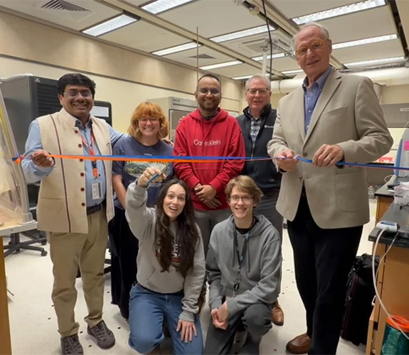 lab members and Dr. Eighmy preparing to cut ribbon