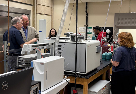 Dr. Eighmy and lab group viewing the spectrometer