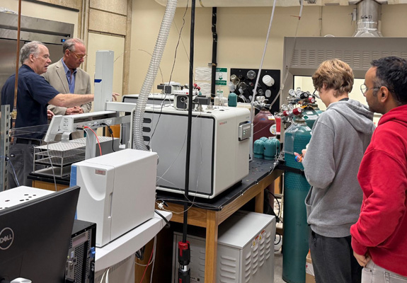 Dr. Eighmy and lab group viewing the spectrometer