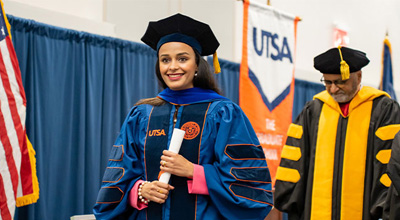 doctoral student crossing graduation stage