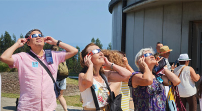 people viewing solar eclipse near the Jurassic Museum in Colunga, Spain