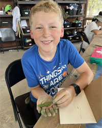 camper holding a leaf with a caterpillar