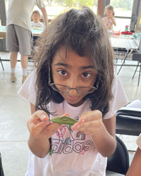 camper holding a leaf with a caterpillar