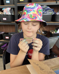 camper holding a leaf with a caterpillar