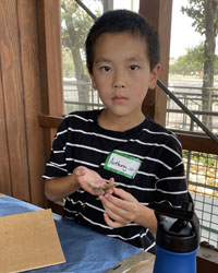 camper holding a leaf with a caterpillar