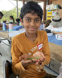 camper holding a leaf with a caterpillar