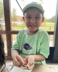 camper holding a leaf with a caterpillar