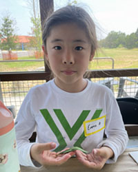 camper holding a leaf with a caterpillar