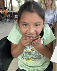 camper holding a leaf with a caterpillar