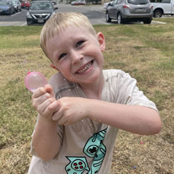 camper holding water balloon