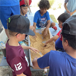 campers working with sand to create rivers