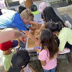 campers working with sand to create rivers