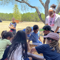 campers working with sand to create rivers