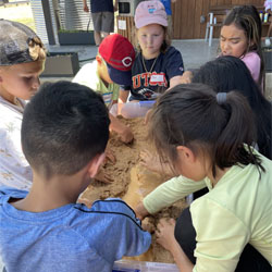 campers working with sand to create rivers