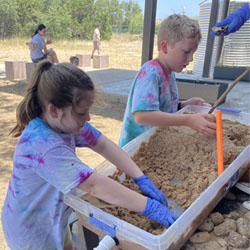 campers working with sand to create rivers