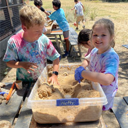 campers working with sand to create rivers