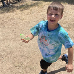 camper running with water balloon