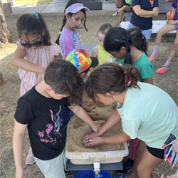 campers working with sand to create rivers