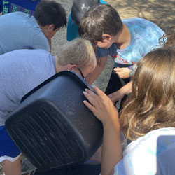 campers working with sand to create rivers