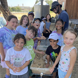 campers working with sand to create rivers