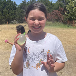 camper holding water balloon