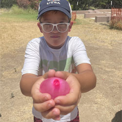 camper holding water balloon