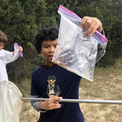 camper holding up bag with insects