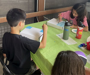 two campers decorating insect boxes