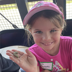 campers holding monarch butterfly caterpillar