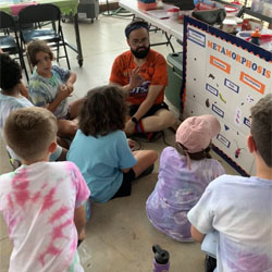 campers on floor around a metamorphosis whiteboard